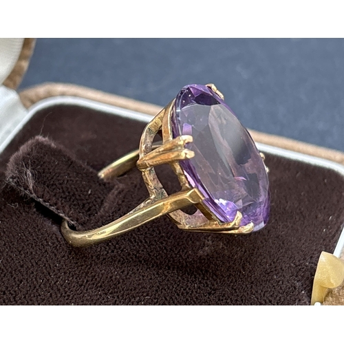 124 - A vintage unmarked yellow gold cocktail ring with large oval cut amethyst in a double pronged open w... 