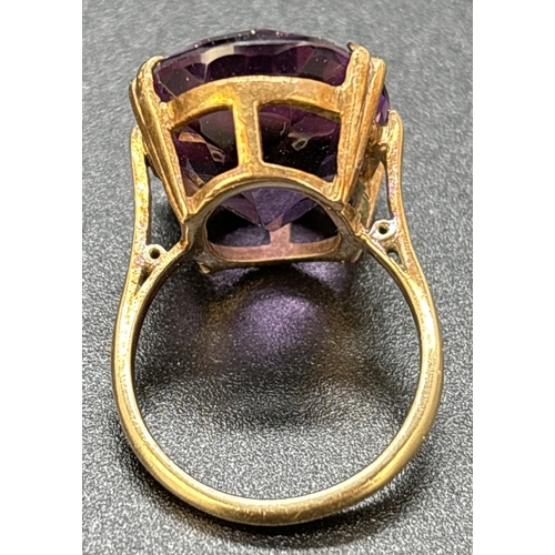 124 - A vintage unmarked yellow gold cocktail ring with large oval cut amethyst in a double pronged open w... 