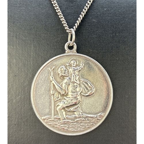 71 - A large silver circular shaped St. Christopher pendant on a 24 inch curb chain with spring ring clas... 