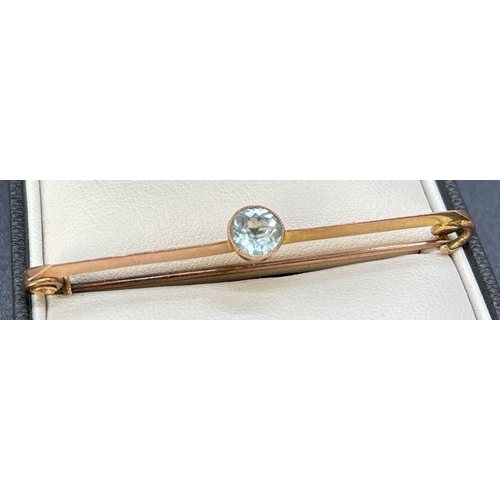 86 - A 9ct rose gold Art Deco bar brooch with central round cut aquamarine stone in a milgrain setting. G... 