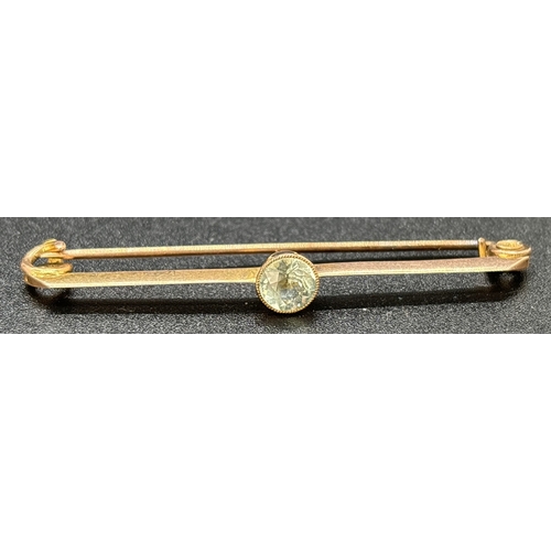 86 - A 9ct rose gold Art Deco bar brooch with central round cut aquamarine stone in a milgrain setting. G... 