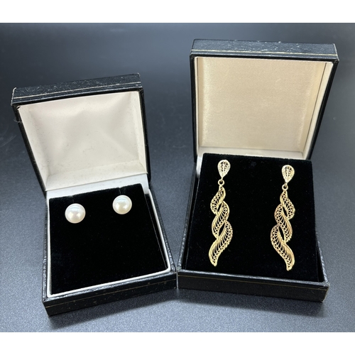 107 - 2 pairs of 9ct gold earrings. A pair of pearl stud earrings together with a pair of filigree wave de... 