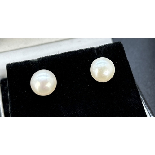 107 - 2 pairs of 9ct gold earrings. A pair of pearl stud earrings together with a pair of filigree wave de... 