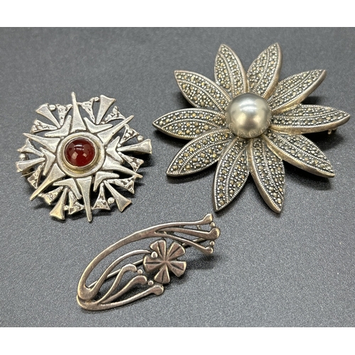 47 - 3 silver brooches. A small floral design brooch, a large flower with central faux pearl and marcasit... 