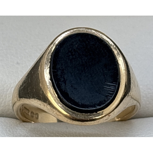 101 - A 9ct gold men's signet ring set with an oval of black onyx. Full hallmarks to inside of plain shank... 