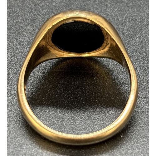 101 - A 9ct gold men's signet ring set with an oval of black onyx. Full hallmarks to inside of plain shank... 