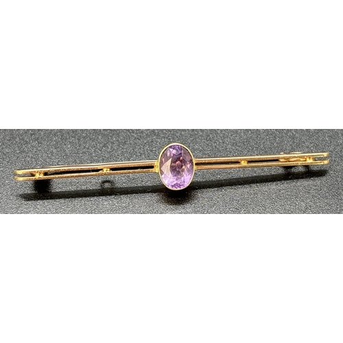 79 - A vintage 15ct gold bar brooch with central milgrain set oval cut amethyst. Gold mark to side of bro... 