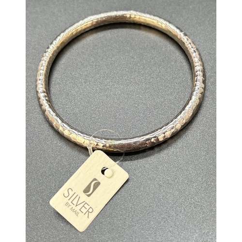 50 - A silver bangle with hammered effect finish by 'Silver By Mail'. With original tag and presentation ... 