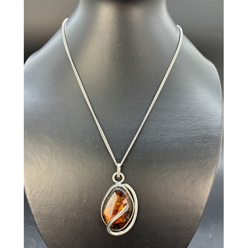 45 - A modern design silver and cognac amber set pendant on a 28 inch curb chain necklace. Silver marks o... 