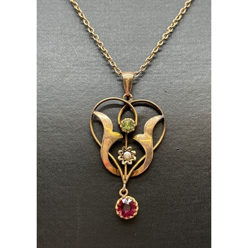 1043 - An Art Nouveau floral design pendant set with a round cut peridot, small seed pearl and a round cut ... 