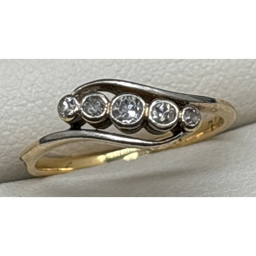 1044 - An 18ct yellow gold Art Deco diamond ring in a crossover design. 5 graduating sized bezel set round ... 