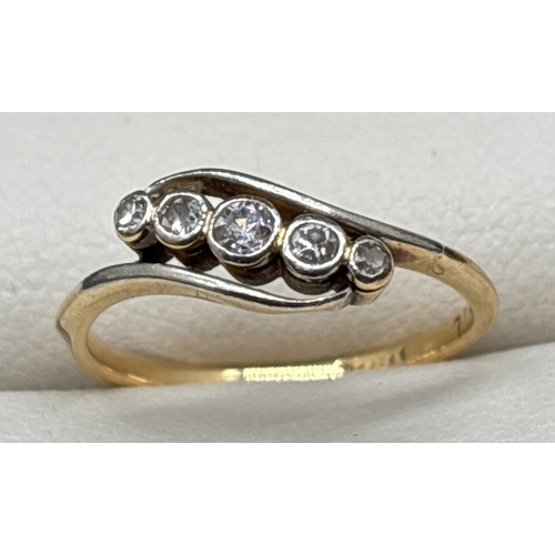 1044 - An 18ct yellow gold Art Deco diamond ring in a crossover design. 5 graduating sized bezel set round ... 