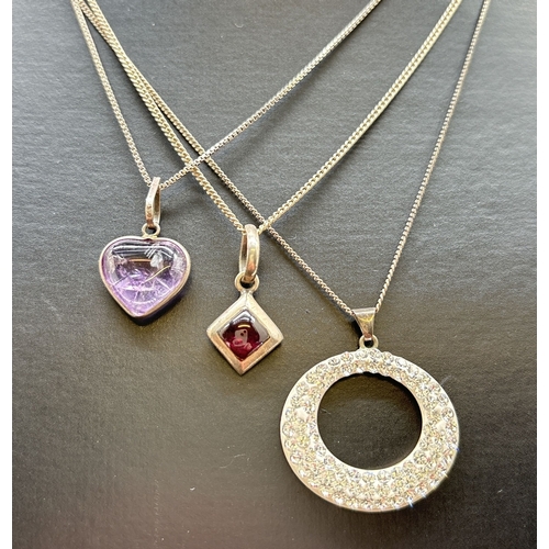 1068 - 3 silver pendant necklaces. A modern design oval pendant set with small clear crystals, on an 18