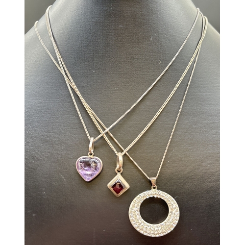 1068 - 3 silver pendant necklaces. A modern design oval pendant set with small clear crystals, on an 18