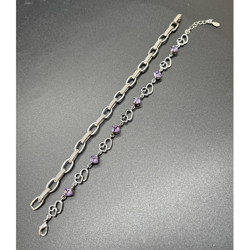 1070 - 2 silver bracelets. A double heart link bracelet with alternating purple crystals and a belcher chai... 