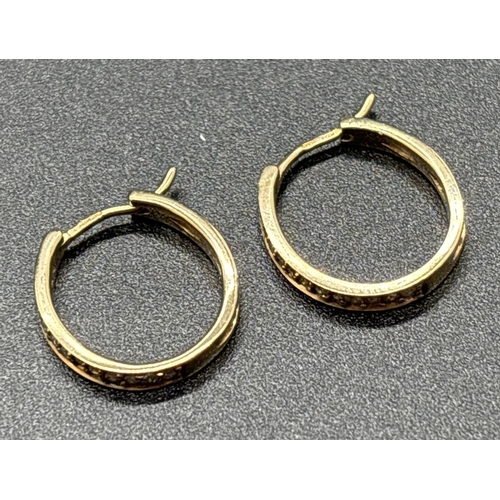 1051 - A pair of 9ct gold diamond set hoop earrings with clip fastening posts. Front of hoops set with smal... 