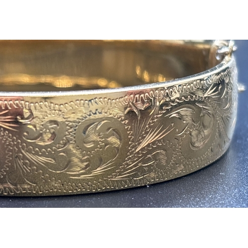 1083 - 2 bangles with half floral engraved decoration - rolled gold and 9ct gold with metal core. Both with... 