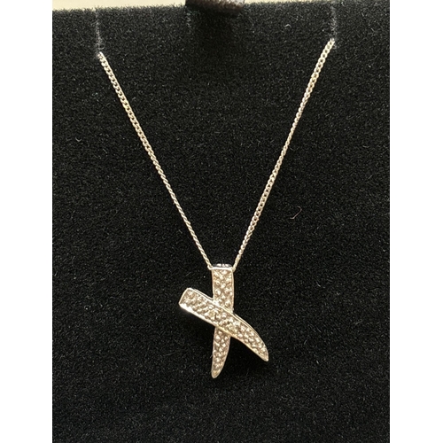 1059 - A boxed 9ct white gold kiss pendant set with diamonds, on a fine curb chain with spring ring clasp. ... 