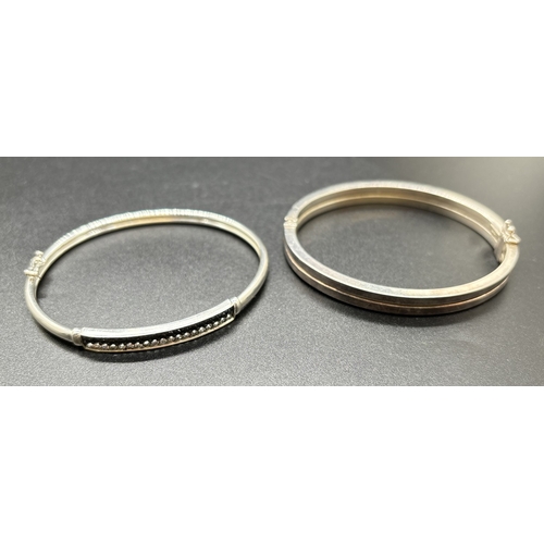 1094 - 2 modern design silver bangles. A double row bangle and a bangle set with black and clear cubic zirc... 