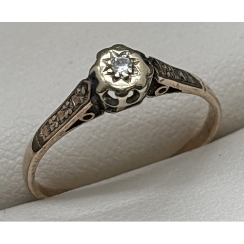 1104 - A 9ct gold diamond solitaire ring with illusion engraved design to shoulders. Stamped 9ct inside ban... 