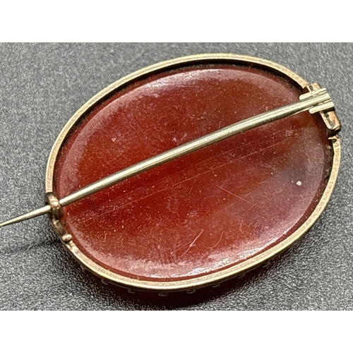 1107 - A late Victorian oval shaped carnelian brooch with unmarked gold mount (tests as 14ct). Hinged pin w... 