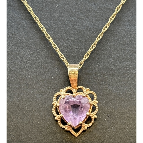 1110 - A 9ct gold heart shaped pendant with scallop edging and central amethyst, on an 18