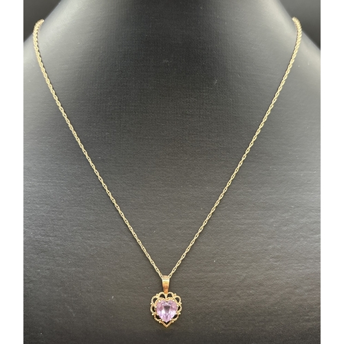 1110 - A 9ct gold heart shaped pendant with scallop edging and central amethyst, on an 18