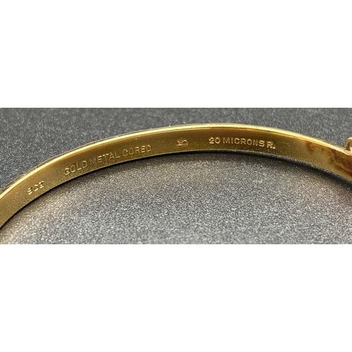 1124 - A vintage 9ct gold metal core bangle with diamond pattern throughout, push clasp and safety chain. G... 