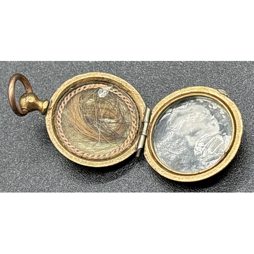 1125 - 2 small Victorian jewellery items. A small rose gold backed mourning brooch with plaited hair behind... 