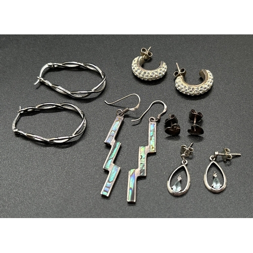 1129 - 5 pairs of silver earrings in stud, drop and hoop styles. To include thunderbolt drops set with abal... 