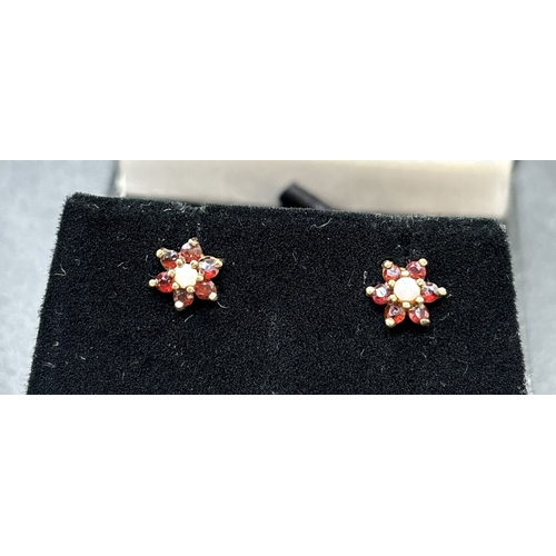 1131 - 2 pairs of 9ct gold earrings. A small pair of 9ct gold garnet and opal set flower head design stud e... 