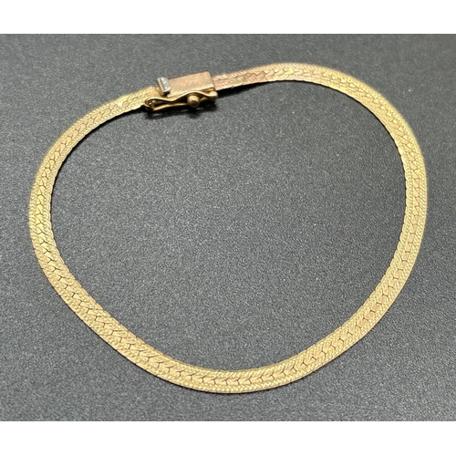 1138 - A vintage 9ct gold 7 inch herringbone chain bracelet with push clasp and safety clip. Weight approx.... 