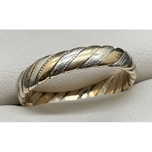 1146 - A 9ct white and yellow gold twist design band ring with milgrain bead detail to white gold. Fully ha... 