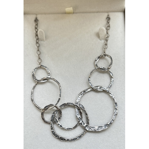 1150 - A boxed Paz Creations 18 inch silver fixed pendant necklace. 8 interlinked hammered effect different... 