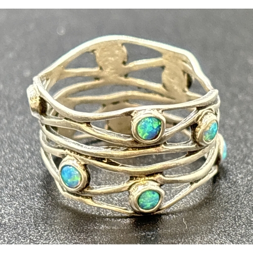 1153 - A modern design open weave band ring with 10 bezel set small round opals. Silver mark inside band. S... 