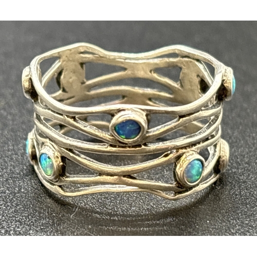 1153 - A modern design open weave band ring with 10 bezel set small round opals. Silver mark inside band. S... 