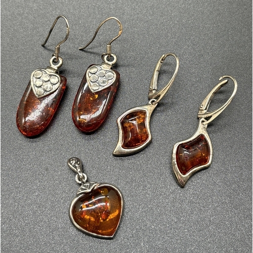 1154 - 2 pairs of cognac amber set drop earrings together with a heart shaped white metal amber set pendant... 