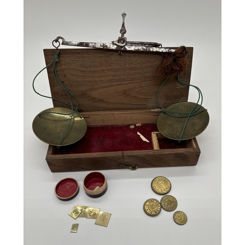 1387 - A set of early 20th century travelling apothecary scales in wooden case, with brass pans and steel b... 