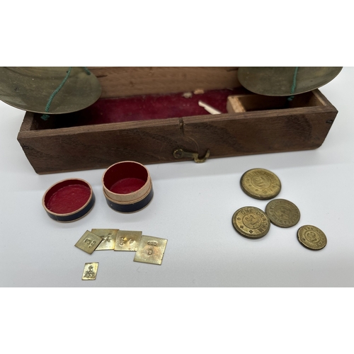 1387 - A set of early 20th century travelling apothecary scales in wooden case, with brass pans and steel b... 