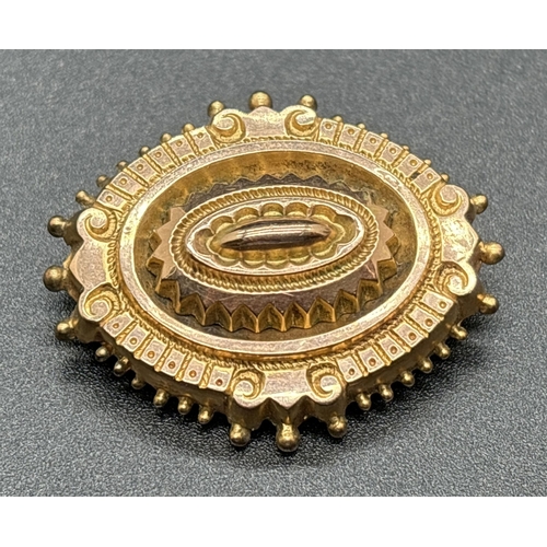 1045 - A Victorian 9ct gold oval shaped mourning brooch with scroll and beaded decoration. Panel to back of... 