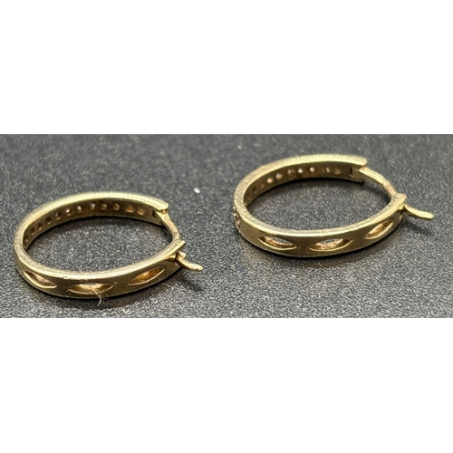 1051 - A pair of 9ct gold diamond set hoop earrings with clip fastening posts. Front of hoops set with smal... 