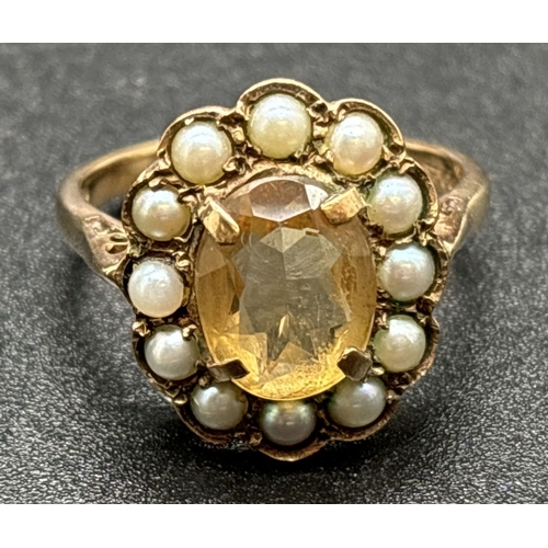 1133 - A vintage 9ct gold citrine and seed pearl dress ring with pierced shoulders and plain shank. Central... 