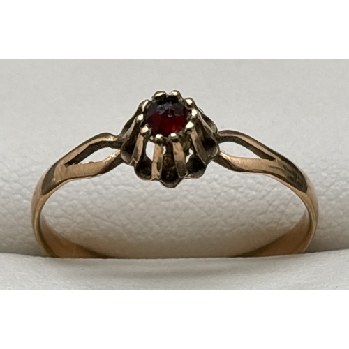 1145 - A vintage 9ct gold ring with high mount set with a single round cut garnet. Split shoulders and plai... 