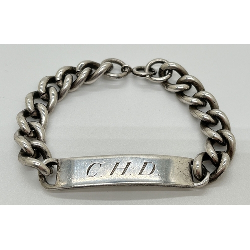 1166 - A vintage silver identity bracelet with heavy curb chain and spring ring clasp. Engraved 'C. H. D' t... 