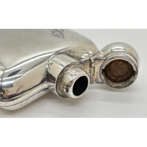 1232 - A vintage silver plated curve backed hip flask with engraved initials C.H.D. Hinged lid with cork li... 