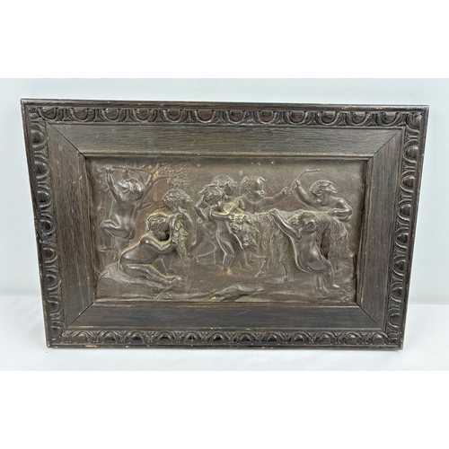 1242 - An antique relief bronze plaque showing cherubs with a goat, mounted in a dark oak frame with carved... 