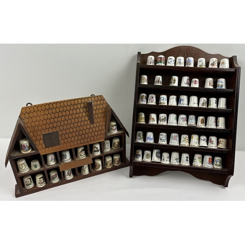 1291 - A collection of 70 assorted ceramic thimbles together with 2 small wooden wall hanging display shelv... 