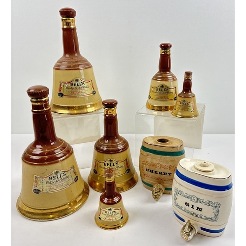 1351 - A collection of Wade ceramic novelty decanters. 6 Bells scotch whisky decanters of varying sizes, to... 