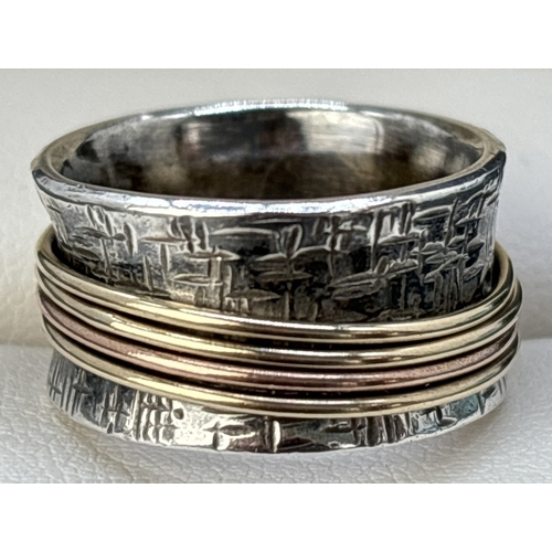 1075 - A contemporary design 958 silver spinner ring. Bamboo effect design to a 11mm wide band with 4 plain... 