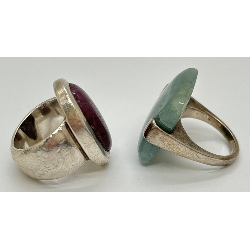 1111 - 2 modern design silver rings. One bezel set with a large oval cut purple natural stone the other wit... 